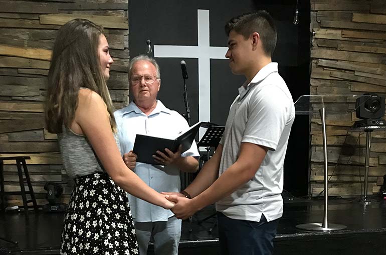 Grace and CJ sharing their vows at their wedding ceremony